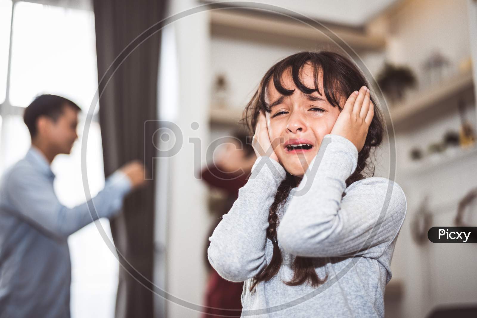 Little Girl Crying Because Of Her Parents Quarreling. Girl Abused With Mother And Father Shouting And Conflict Angry Background In Home. Family Dramatic Scene, Family Social Issues Problem Concept.