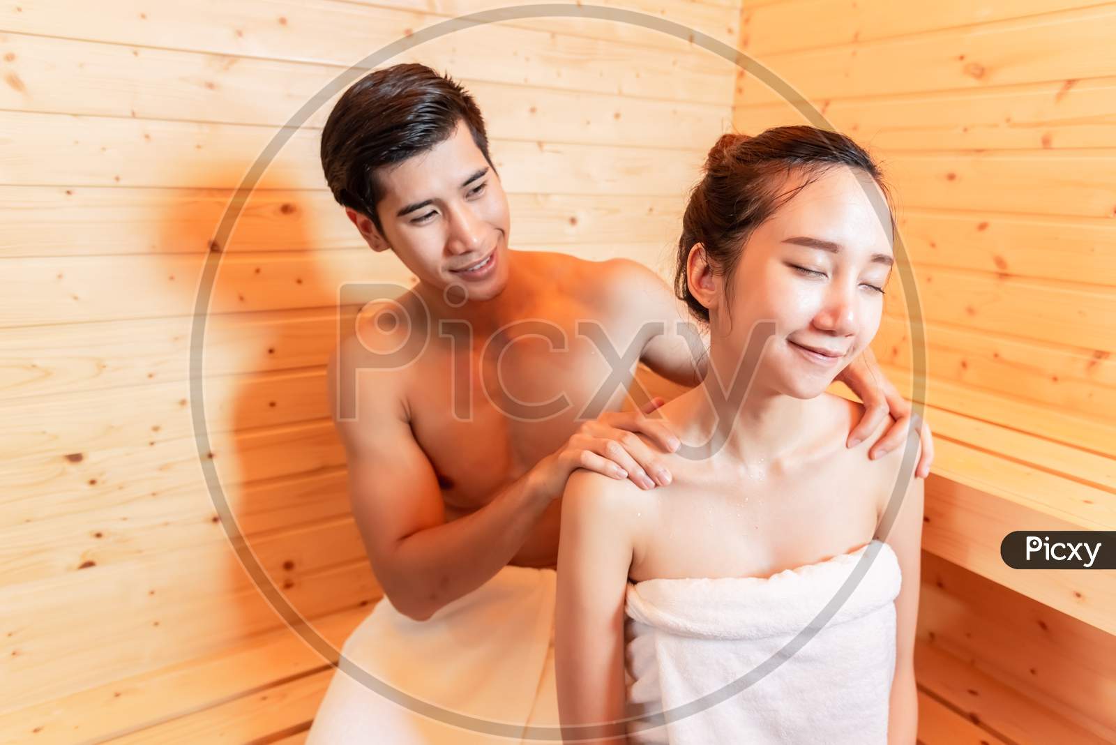 Young Asian Couples Have Romantic Relaxing Massage In Sauna Room. Skin Care Heat Treatment And Body Clean Up And Refreshing In Spa Steam Bath. Healthy And Honeymoon Concept. Happiness Valentines Day