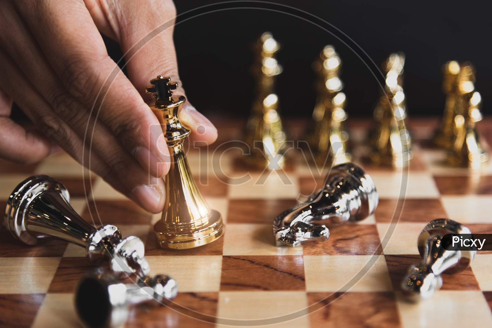 Hand Of Businessman Moving Golden Chess Figure For Eliminating In Battle Competition With Last Successful Ending Game. Leadership Strategy And Management Tactic Concept. Wooden Checkmate Chessboard