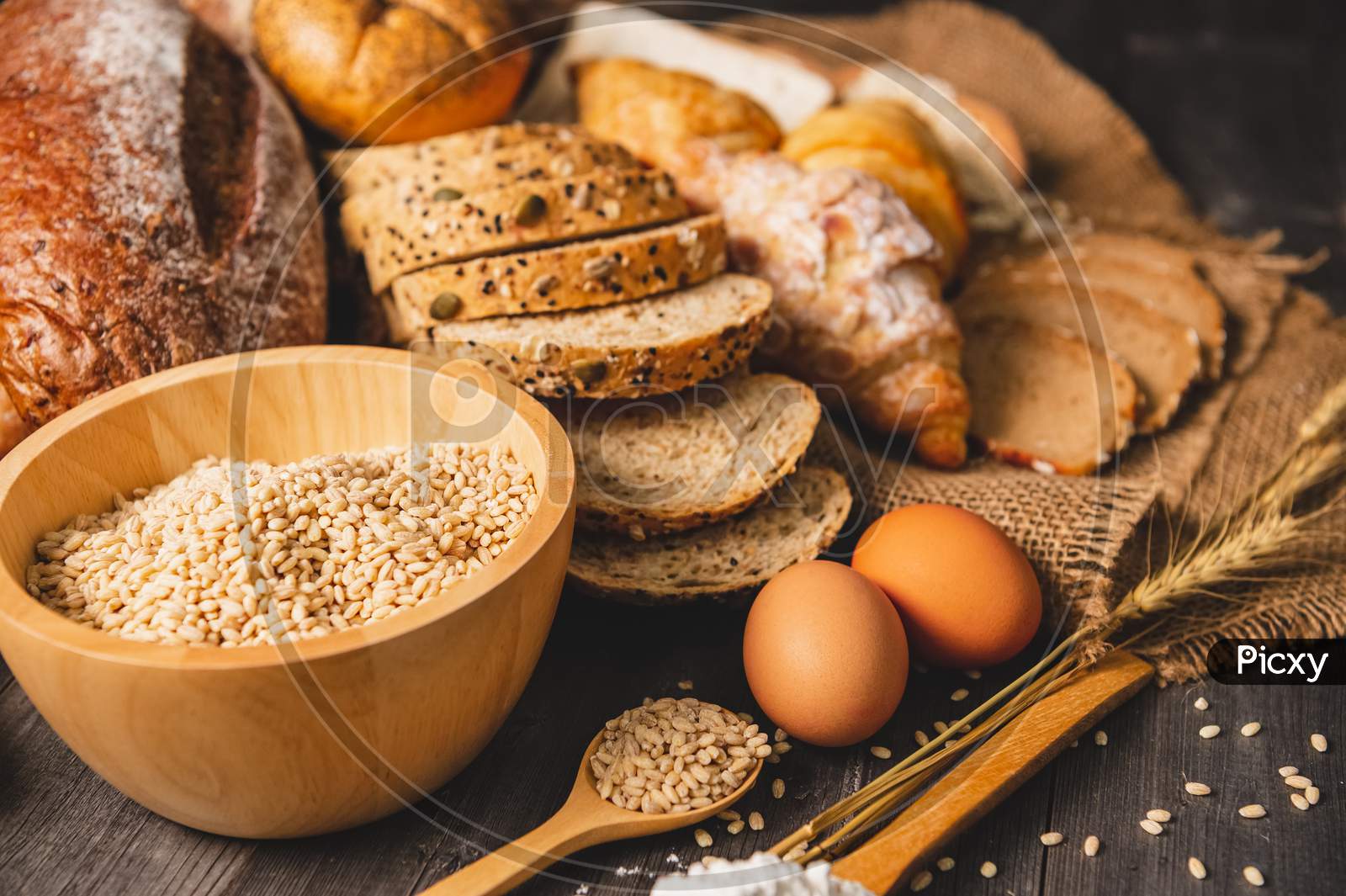 Different Kinds Of Bread With Nutrition Whole Grains On Wooden Background. Food And Bakery In Kitchen Concept. Delicious Breakfast Gouemet And Meal.