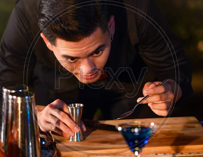 Professional Bartender Preparing Fresh Juice Cocktail In Drinking Wine Glass With Ice At Night Bar Clubbing Counter. Occupation And People Lifestyles Concept. Outdoor And Nightclub Background