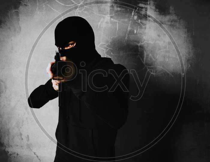 Terrorist Shooting With His War Gun Weapon With Grunge Room Wall Background. Criminal And Dangerous Illegal People Concept. Terrorist And War Theme. Dark Tone And High Contrast Use