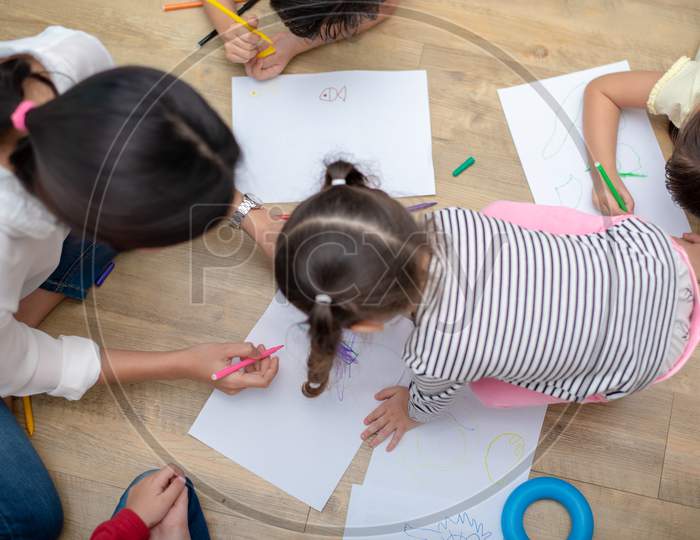 Group Of Preschool Student And Teacher Drawing On Paper In Art Class. Back To School And Education Concept. People And Lifestyles Theme.  Room In Nursery