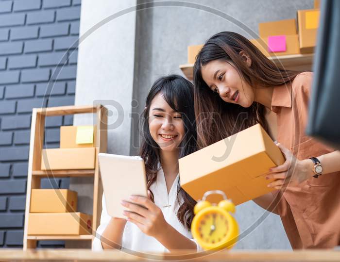 Two Young Asian Women Startup Small Business Entrepreneur Sme Distribution Warehouse With Parcel Mail Box. Small  Owner Home Office. Online Marketing And Product Packaging And Delivery Service