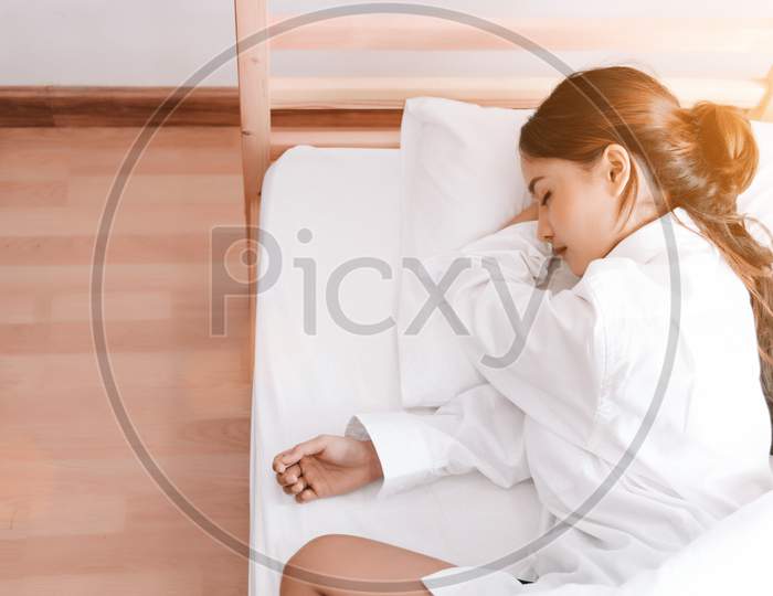 Young Asian Woman Sleeping On White Bed In The Morning. Beauty And Holiday Concept. Vacation And Relax Theme. Interior And People Theme. Top View