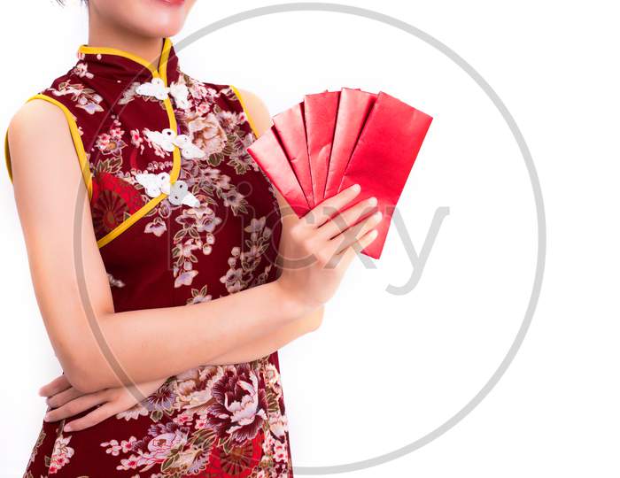 Close Up Red Packet Of Moneys In Woman Hands And Holding Packet Of Moneys Gesture In Chinese New Year Festival Event On Isolated White Background. Lifestyle Concept. Qipao Or Cheongsam Dress