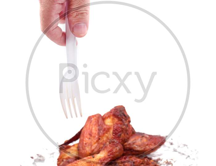 Hand Holding Serving Roasted Chicken In Aluminum Foil With Plastic Fork. Food And Appetizer Concept. Kitchen And Cooking Theme. Delicious Grilled Leg And Wing On Isolated White Background