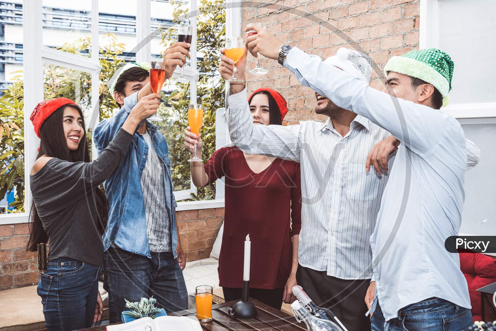Outdoor Xmas Party Shot Of Young People Toasting Drinking Glass At A Rooftop Terrace As Forever Friendship. Young Friends Hang Out With Alcohol Drinking And Juice. Christmas And New Year Party Theme.