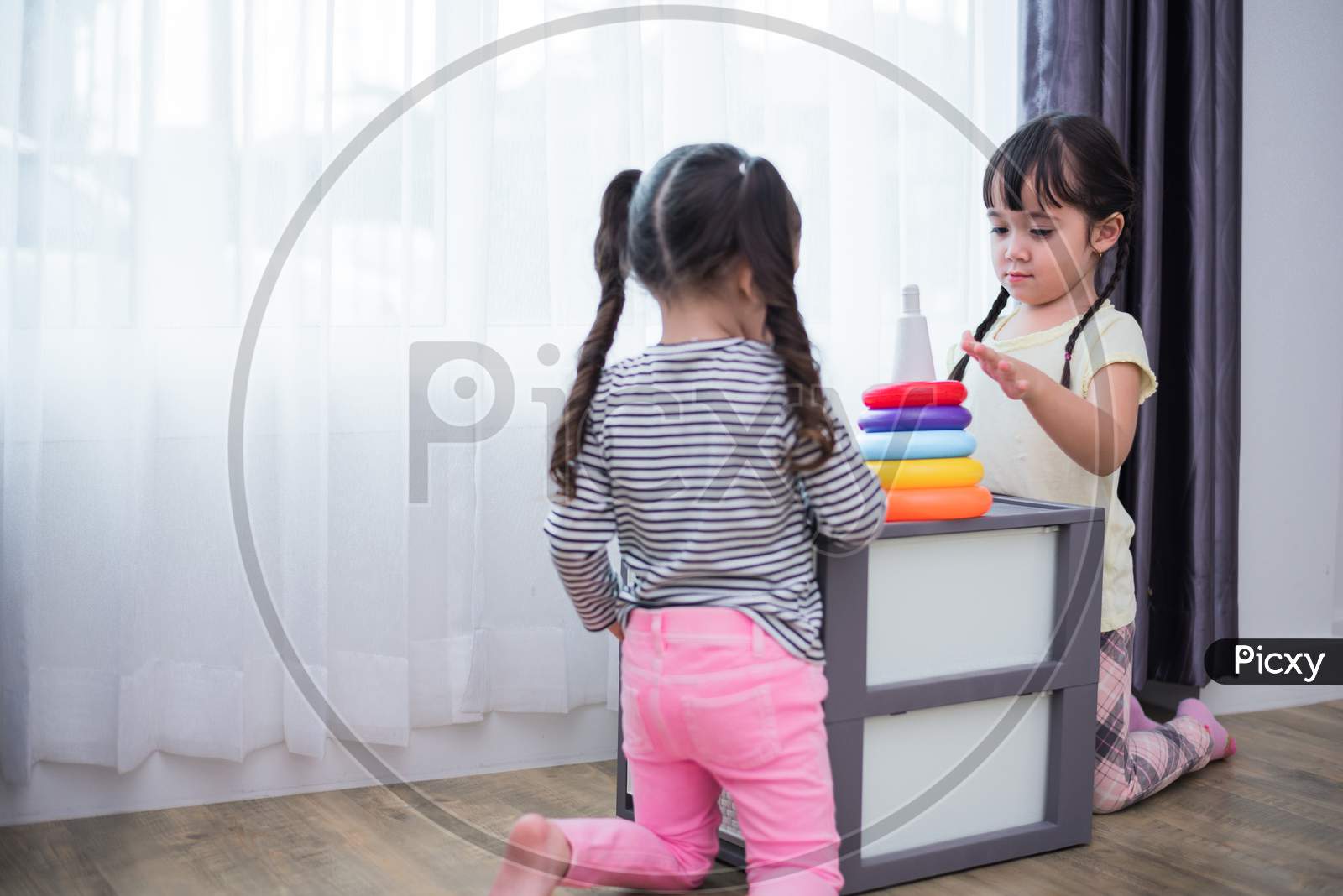 Two Little Girls Playing Small Toy Balls In Home Together. Education And Happiness Lifestyle Concept. Funny Learning And Children Development Theme. Group Of Kids