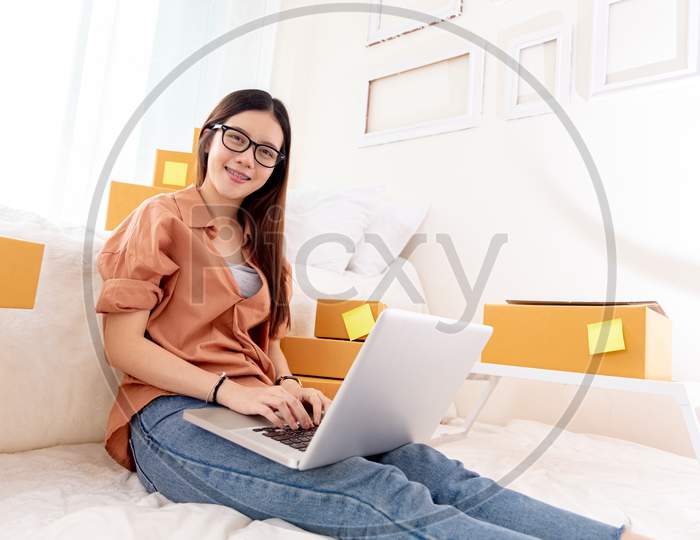 Beauty Asian Woman Using Laptop For Customer Support In Bedroom. Business Technology Concept. Delivery Online Shopping. Service. People Lifestyle Remote Work In Domestic House. Looking At Camera