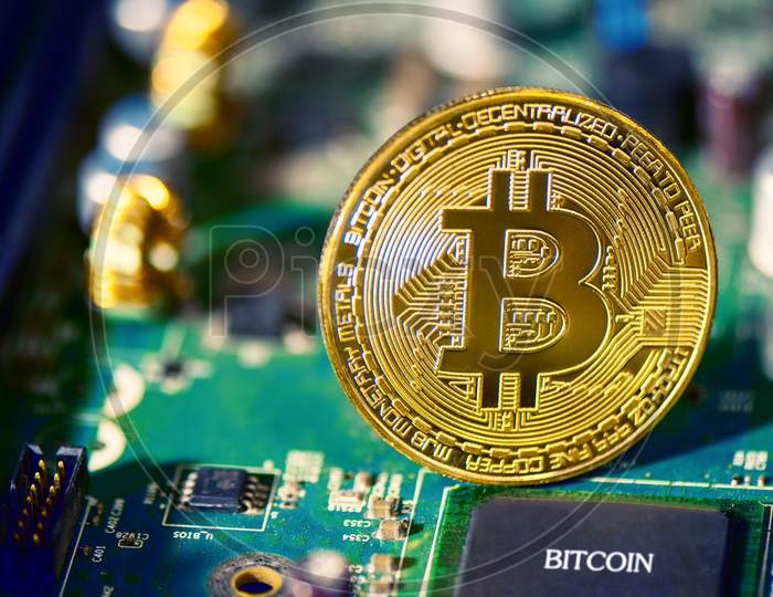Bitcoin On Electronic Circuit Board. Cryptography And Electronic Money Concept. Currency Trading And Gold Mining Theme. Business And Technology Theme.