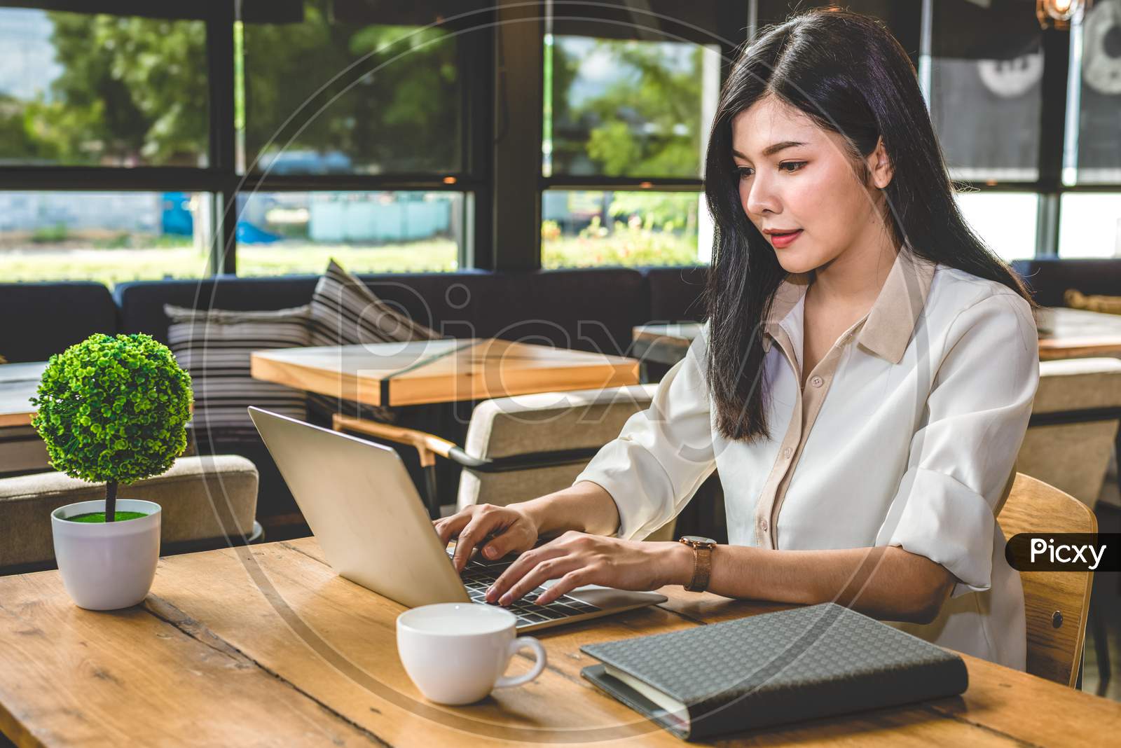 Asian Woman Working With Laptop In Coffee Shop. People And Lifestyles Concept. Job And Occupation Working And Freelance Theme.