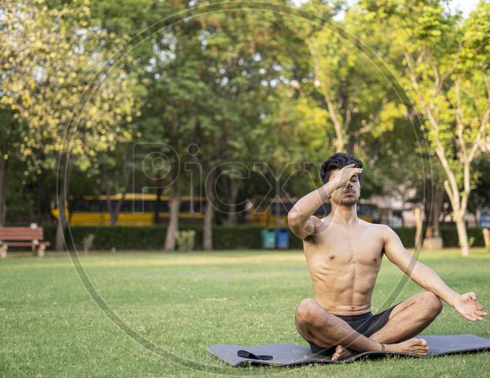 A Young Indian Shredded Teenage Boy Doing Yoga Aasan In The Park On International Yoga Day, Anulom Vilom Aasan.