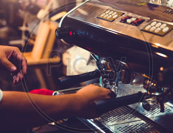Closeup Of Professional Male Barista Hand Making Cup Of Coffee With Coffee Maker Machine In Restaurant Or Coffee Shop. People And Lifestyles. Business Food And Drink Concept. Shop Owner Theme