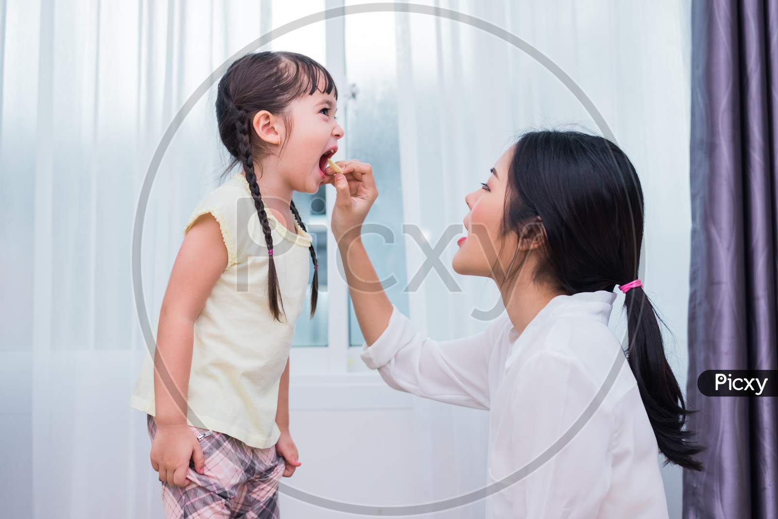 Mom Feeding Kids With Potato Chip. Teacher Feeding Student With Snack. Back To School And Education Concept. Children And Kids Theme. Home Sweet Home And Nursery Theme.