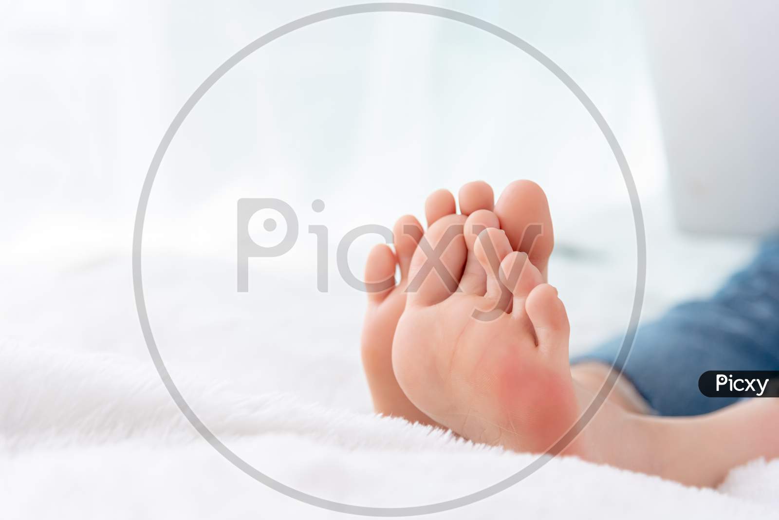 Closeup Woman Feet Skin Wearing Jeans On White Bed. Healthcare And Health Medical Concept.