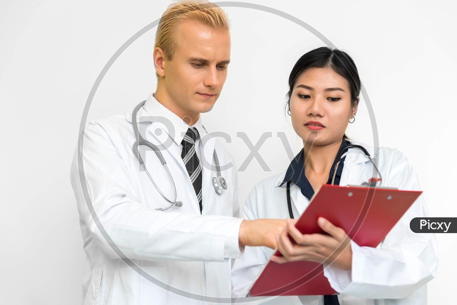 Doctor And Assistant Nurse Checking Patient Laboratory Test. Two Hospital Workers Discussing On Checking Result List. Medical And Healthcare Concept. People And Lifestyles Theme.