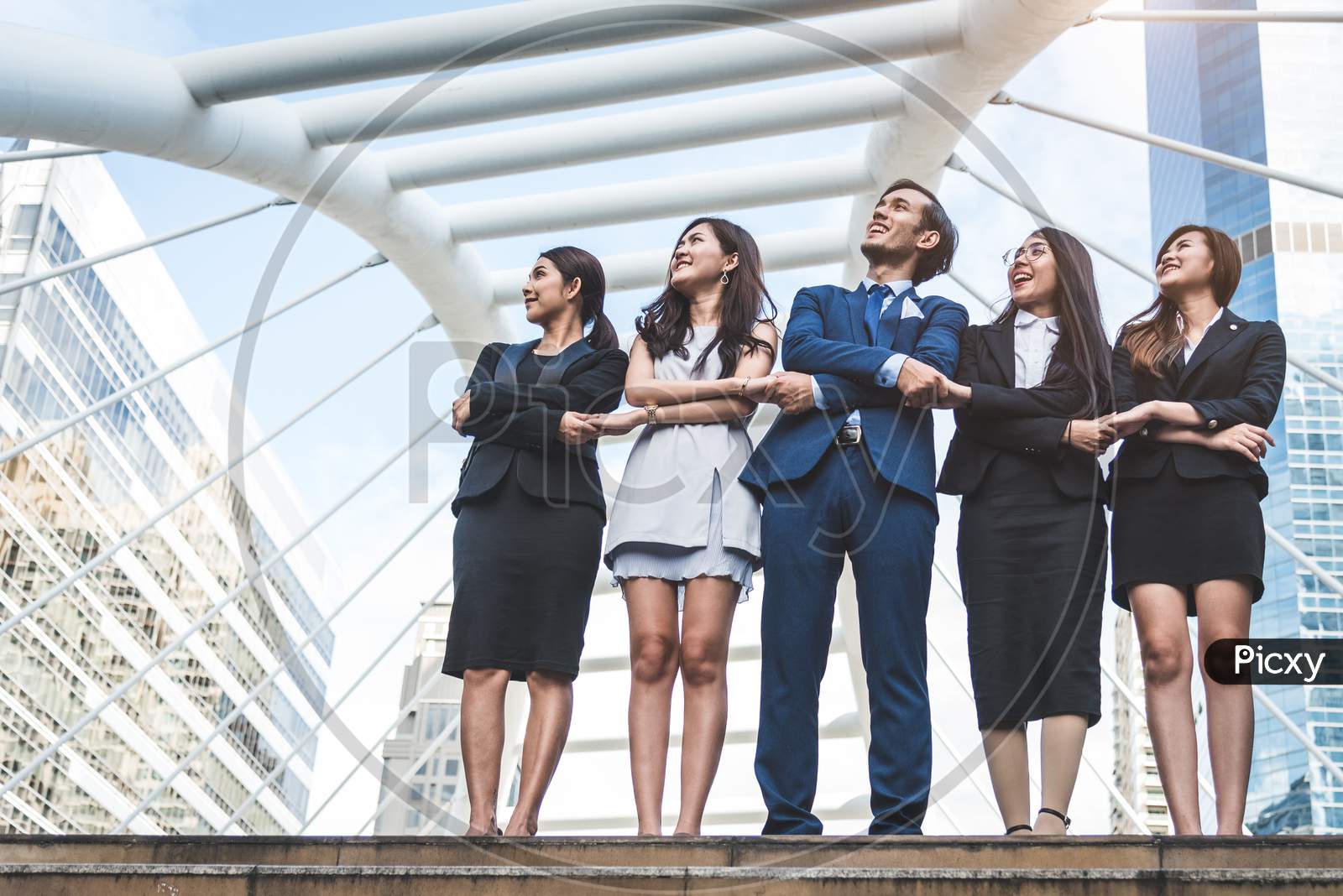 Portrait Of Successful Group Of Business People Looking Up To Sky As Future. Happy Businessmen And Businesswomen Team In Satisfaction Gesture. Successful Group Of People Smiling In City Background