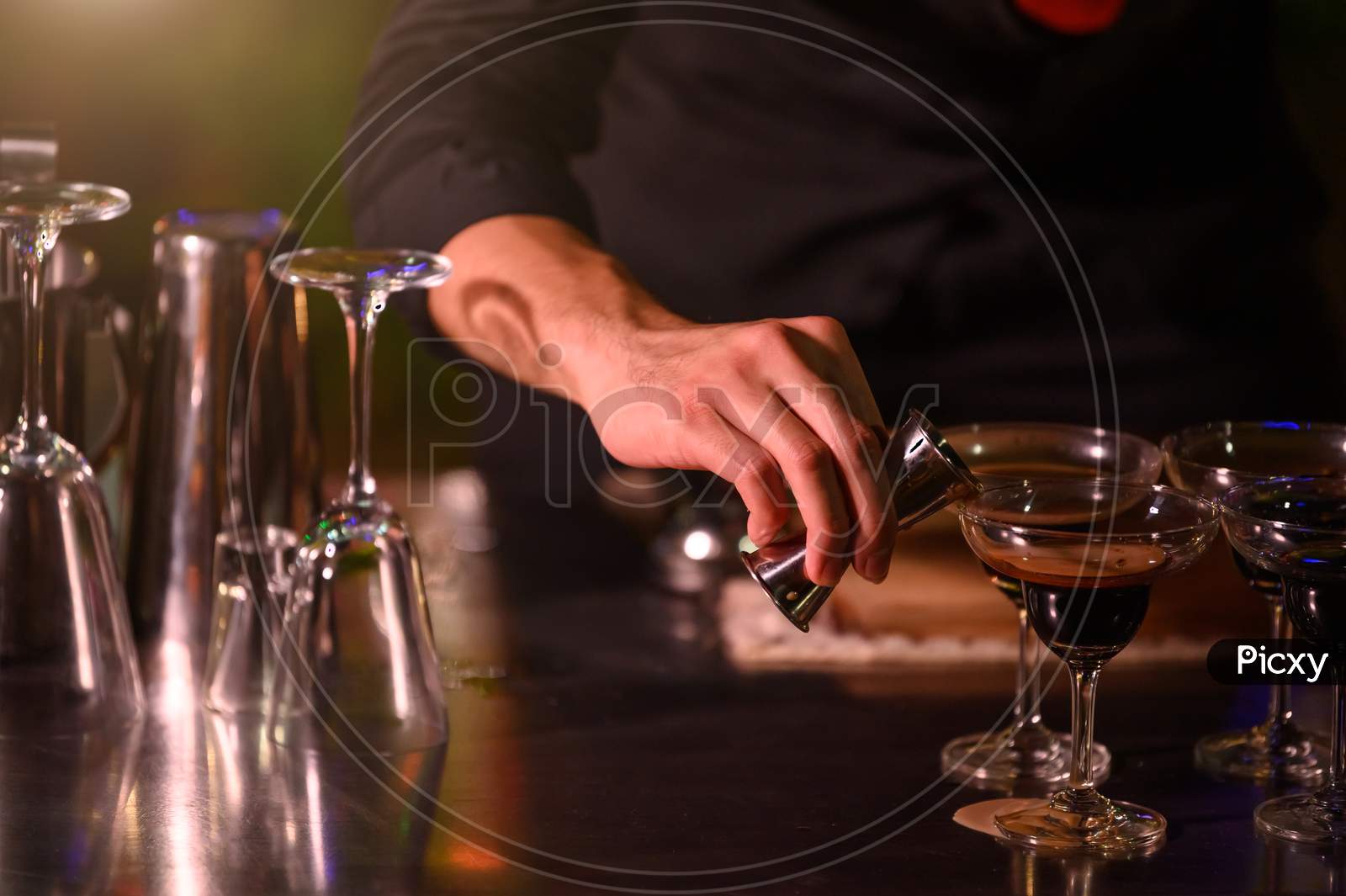 Closeup Bartender Hand Preparing Fresh Juice Cocktail In Drinking Wine Glass With Ice At Night Bar Clubbing Counter. Occupation And People Lifestyles Concept. Outdoor And Nightclub Background