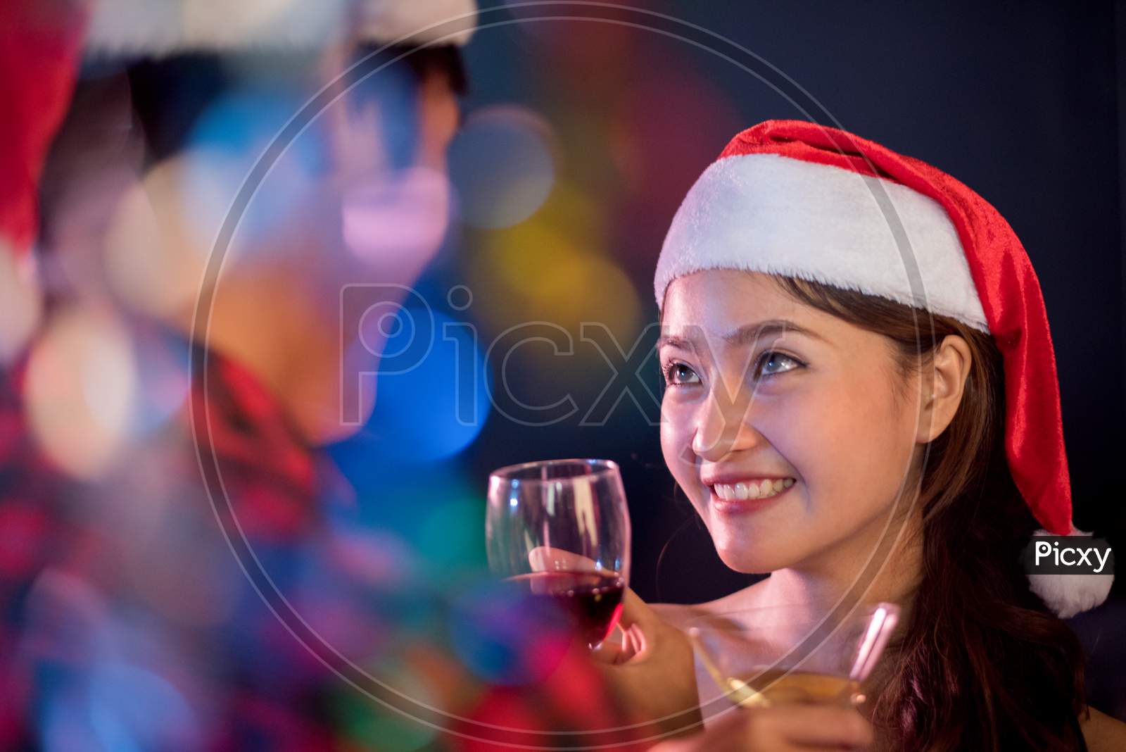 Asian Woman Looking At Her Boyfriend In Christmas And New Year Party. Night Life And First Love Concept. First Impression And Happiness Concept. Couples And Lovers Theme. Color Blurry Bokeh Foreground