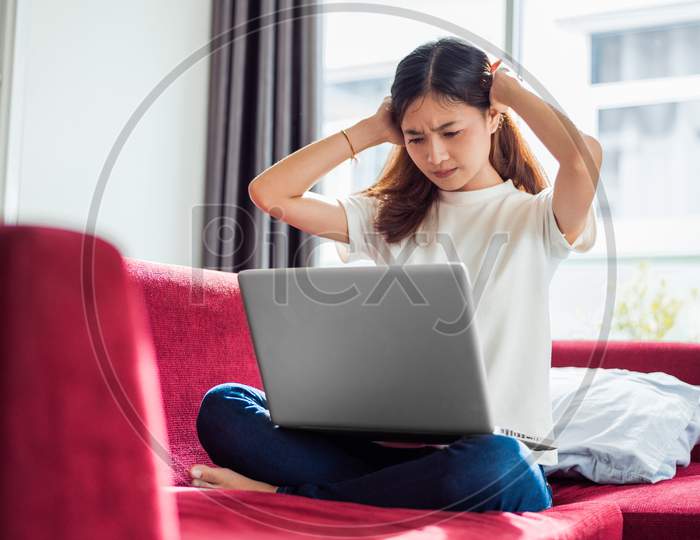 Asian Young Exhausted Businesswoman Having Headache While Using Laptop On  Sofa In Her House. Business People Worry And Stress About Job Deadline Concept. Online Shopping Marketing Technical Problem