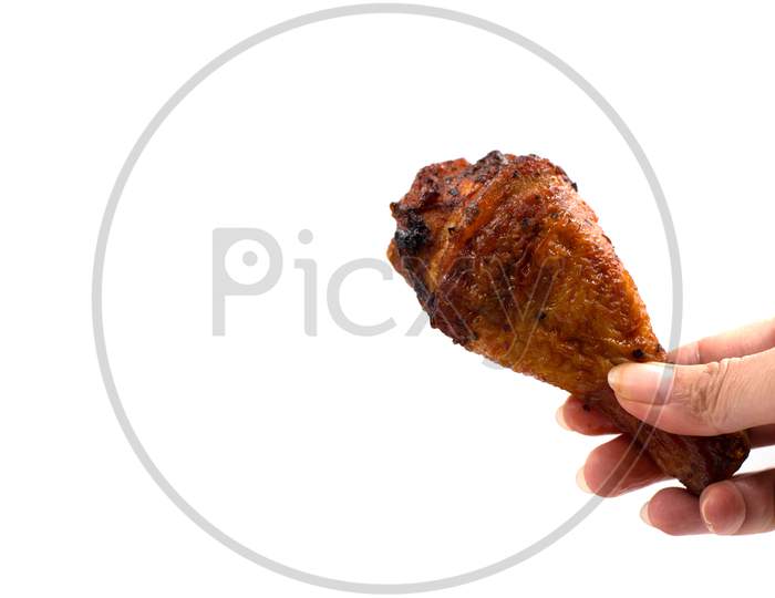 Hand Catching Roasted Chicken Leg. Delicious Grill Chicken On Foil On Isolated White Background. Food And Appetizer Concept