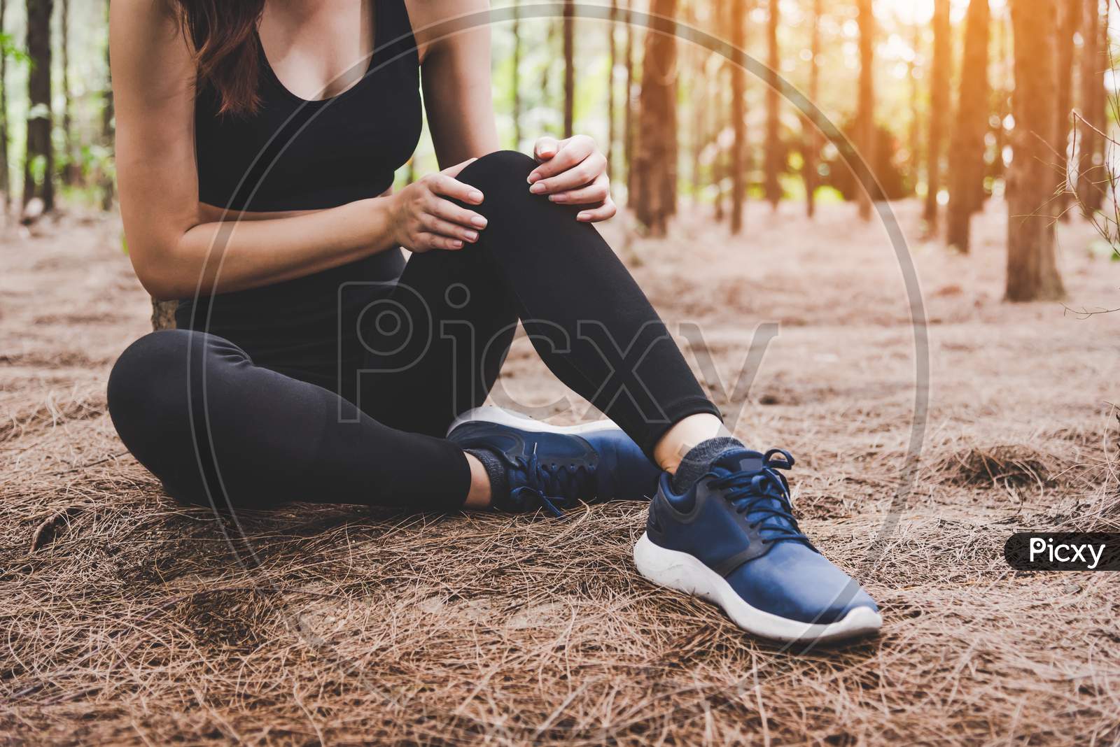 Girl Has Sport Accident Injury In Forest At Outdoors. Healthy And Medicine Concept. Adventure And Travel Concept. Pine Woods Theme.