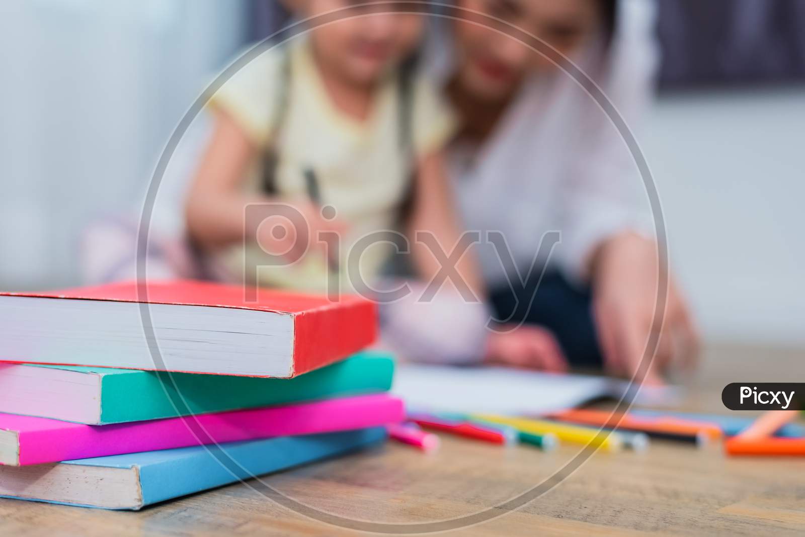 Close Up Of Books On Floor With Mom And Kids Background. Back To School And Education Concept. Children And Teacher Theme.