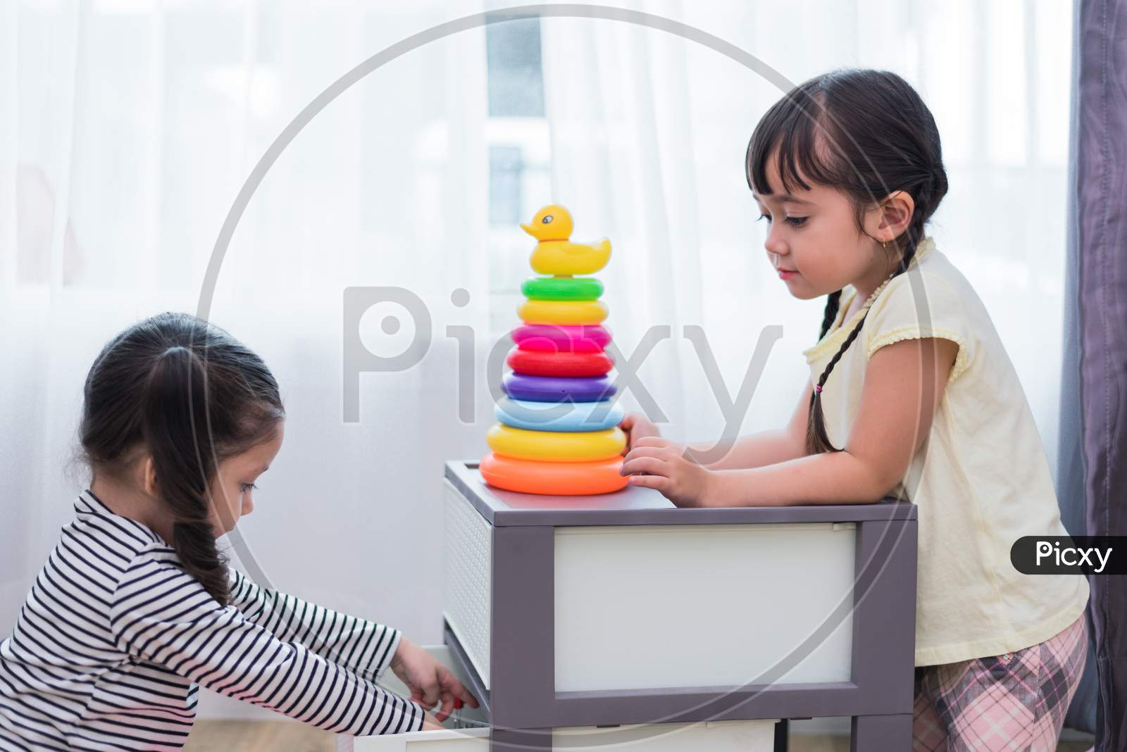 Two Little Girls Playing Small Toy Balls In Home Together. Education And Happiness Lifestyle Concept. Funny Learning And Children Development Theme. Group Of Kids