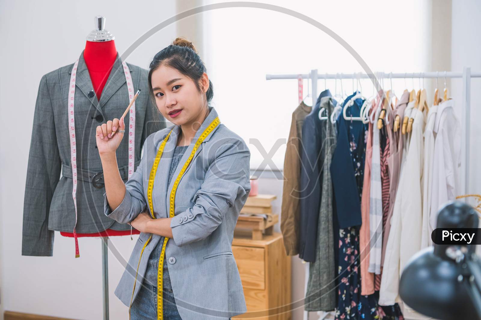 Fashion Designer Stylist In Business Owner Workshop. Tailor And Sewing Concept. Portrait Of Happy Casual Trendy Fashion Designer Businesswoman In Studio Looking Camera. Business Job And Occupation