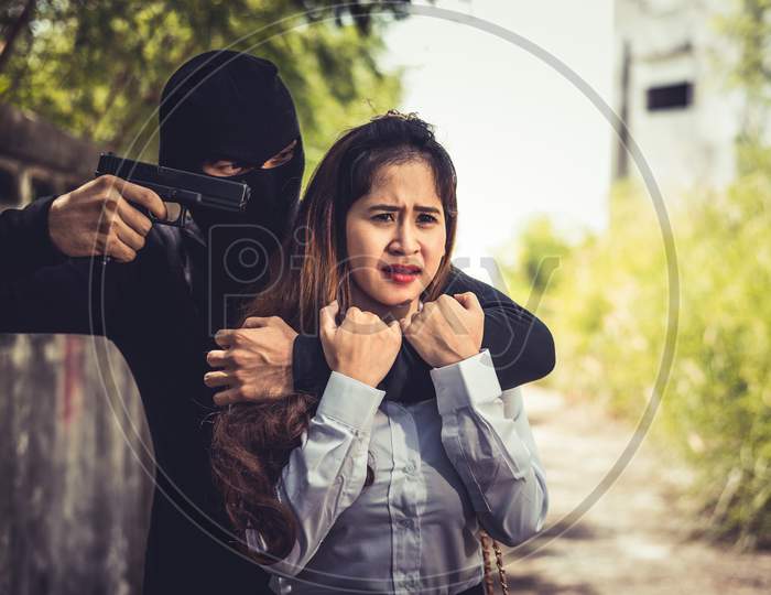 Kidnapper Or Robber Force Knifepoint Woman Hostage To Take Off Her Clothes Or Steal Her Money At Outdoors Road. Raping Sexual And Criminal Theme. Social Issues And Problem Concept
