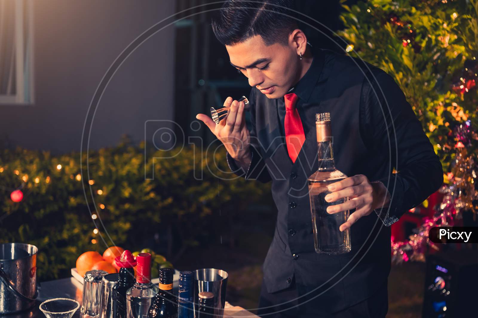 Professional Bartender Preparing Fresh Lime Lemonade Cocktail In Drinking Wine Glass With Ice At Night Bar Clubbing Counter. Occupation And People Lifestyles Concept. Outdoor Background