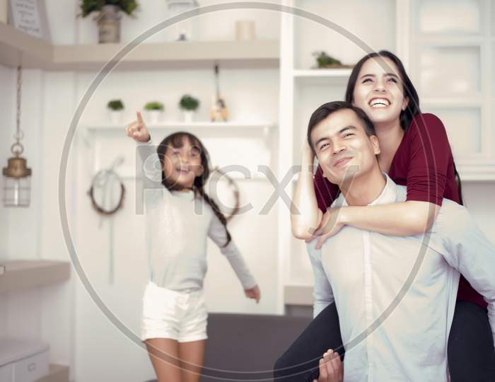 Happy Family Looking Outside With Happy Moods, Mom Ride Back On Dad, Girl Pointing To The Outside With Happy Face Mood, Family And Happiness Concept  Selective Focus