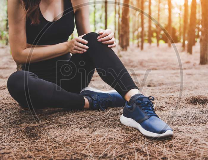 Girl Has Sport Accident Injury In Forest At Outdoors. Healthy And Medicine Concept. Adventure And Travel Concept. Pine Woods Theme.