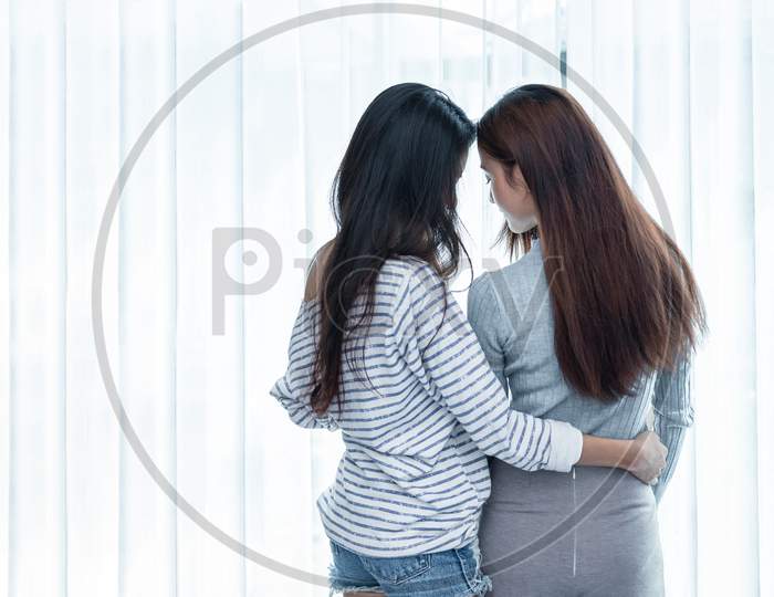 Two Asian Lesbian Women Looking Together In Bedroom. Couple People And Beauty Concept. Happy Lifestyles And Home Sweet Home Theme. Embracing Of Homosexual. Love Scene Making Of Female. Back View Angle