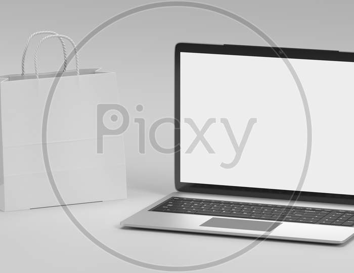 Laptop And Shopping Bag Mockup On White Background. Business And Online Technology Object Concept. Empty Screen Display For Insert Your Advertisement. 3D Illustration Rendering