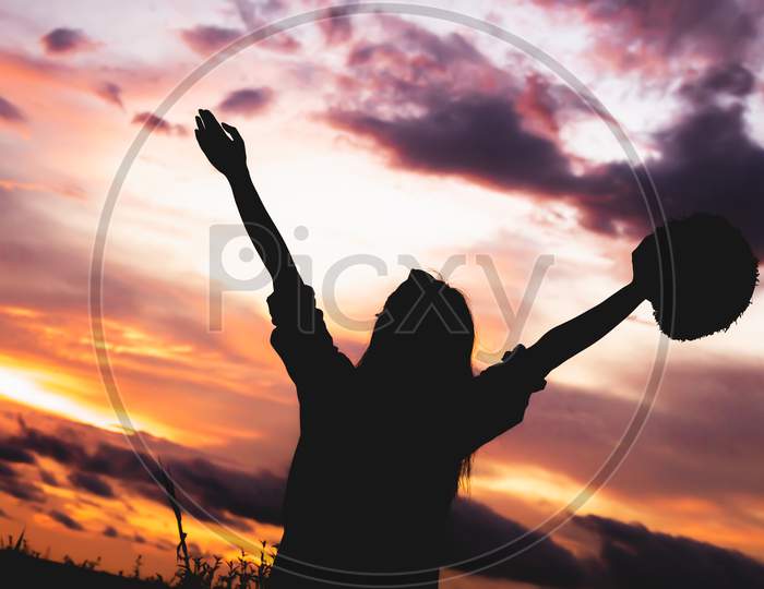Silhouette Of Happy Woman Open Arms Under Sunrise At Seaside With Sunset  Background During Travel In Holiday. Strong Confidence Cheerful Girl With Dawn Sky. Sun And Nature. Weekend Vacation Concept