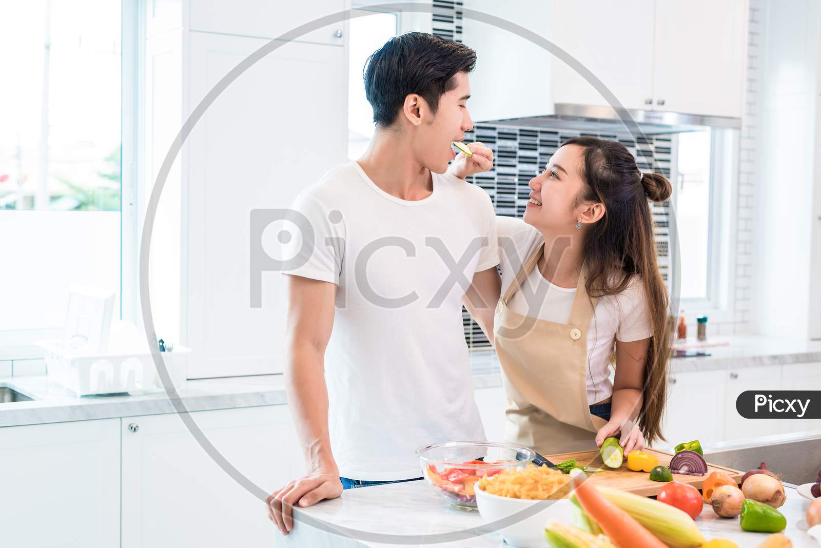 Asian Lovers Feeding Fruit And Food To Each Other, Couple And Family Concept. Sweet Honeymoon And Holidays Theme. Holiday And Indoor Interior