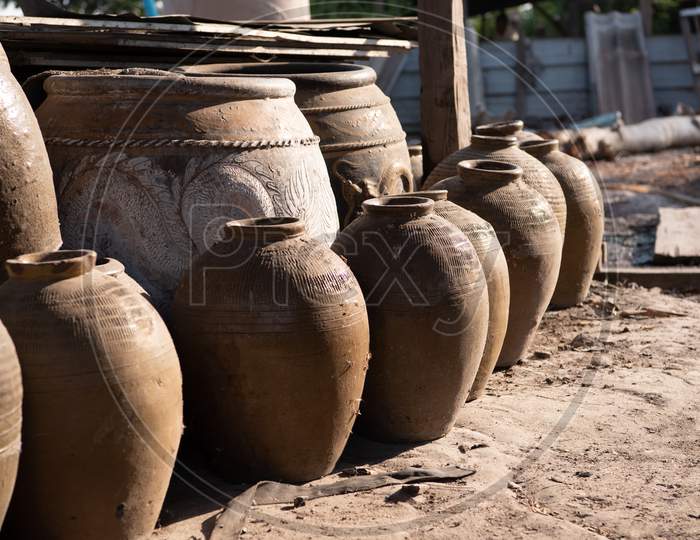 Old Thai Traditional Clay Jars On Outdoors Ground. Group Of Thai Dragon Classical Antique Pattern Vase In Ratchaburi Province Of Thailand. Industrial And Handmade Manufacturing Concept.
