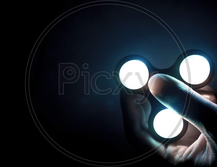 Fidget Spinner Toy With Neon Light Consist Of Ball-Bearing Made From Metal Or Plastic Helping People Who Have Trouble With Focusing By Relieving Nervous Energy Or Psychological Stress. Selective Focus