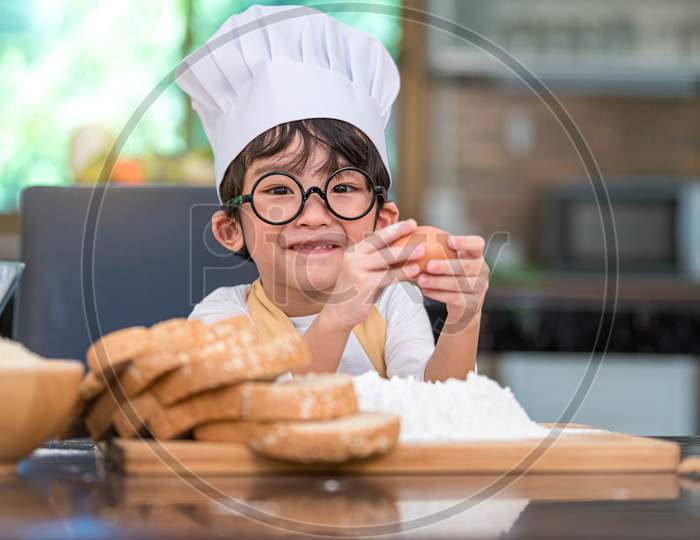 Portrait Cute Little Asian Happy Boy Interested In Cooking Funny In Home Kitchen. People Lifestyles And Family. Homemade Food And Ingredients Concept. Baking Christmas Cake And Cookies. Smiling Child