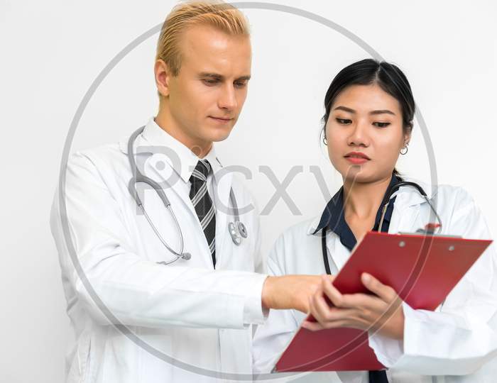 Doctor And Assistant Nurse Checking Patient Laboratory Test. Two Hospital Workers Discussing On Checking Result List. Medical And Healthcare Concept. People And Lifestyles Theme.
