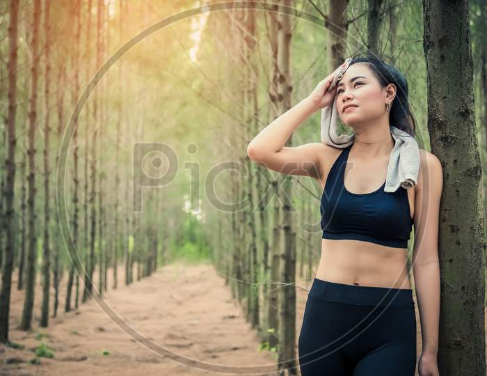 Asian Beauty Woman Wiping The Sweat In Forest. Towel And Sweat Elements. Sport And Healthy Concept. Jogging And Running Concept. Relax And Take A Break Theme. Outdoors Activity Theme.