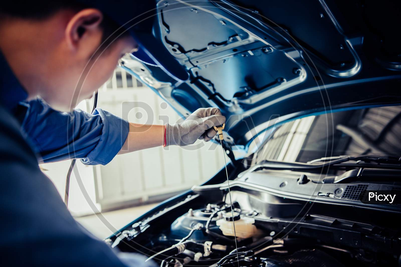 Car Mechanic Holding Checking Gear Oil To Maintenance Vehicle By Customer Claim Order In Auto Repair Shop Garage. Engine Repair Service. People Occupation And Business Job. Automobile Technician