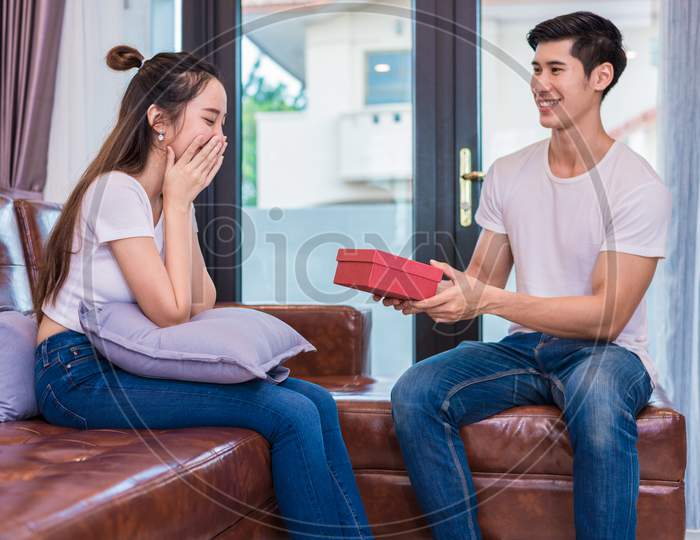 Boyfriend Surprising Girlfriend With Present. Woman Surprised When Looking At Gift Box On Special Day. Lovers And Couples Concept. Honeymoon And Dating Theme. Happiness And Valentines Day Theme.