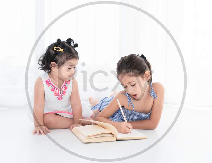Happy Two Sister Drawing In Sketch Book Together At Home Or Nursery. People Lifestyle And Kids Play. Education And Children Concept. Diverse Ethnicity And Ages. Back To School Theme
