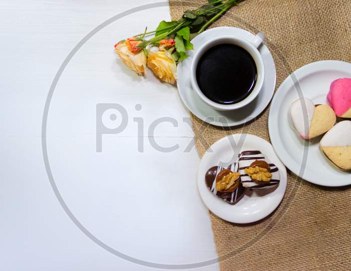 Romantic Flowers With Coffee And Sweet Treats On The Table