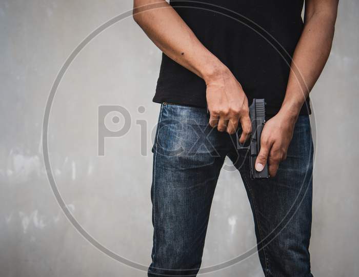 Robber Holding Gun For Ready To Murder Steal Moneys At Abandoned Building. Selective Focus. Criminality And Social Issues Concept. Dark And Low Key Tone Tone Pinterest And Instragram Like Process.