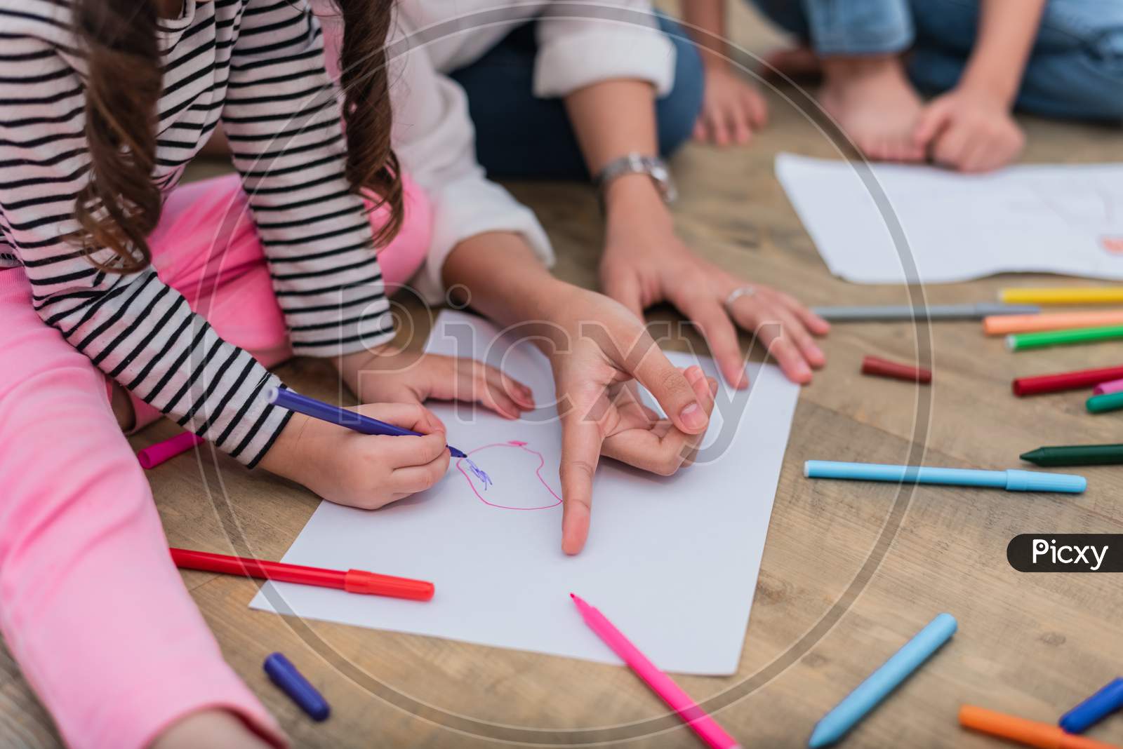 Closed Up Hands Of Mom Teaching Little Children To Drawing Cartoon In Art Class With Color Pen. Back To School And Education Concept. Family And Home Sweet Home Theme. Preschool Kids Theme