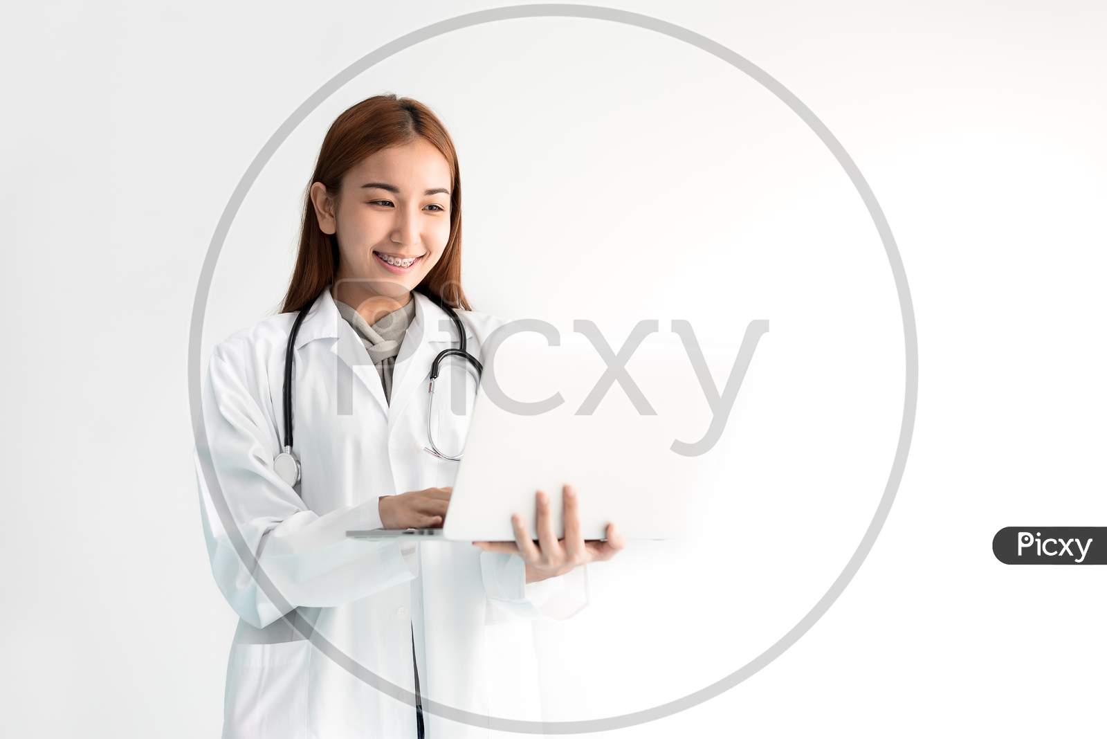 Female Doctor Using Laptop With Stethoscope On White Background. Medical And Healthcare Concept. People And Technology Theme